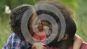 Parents taking care of adopted child, picnic in park, support and understanding