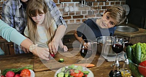 Parents Teaching Children Cooking Together In Kitchen, Happy Family Preparing Food Together Using Tablet Computer With