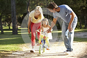 Parents Teaching Daughter To Ride Bike