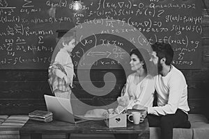 Parents teaching kid at home. Boy presenting his knowledge to mom and dad. Parents listening their son, chalkboard on