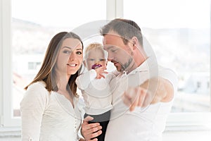 Parents with their beautiful baby girl at home. Family values.