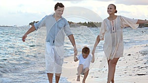 Parents and their child walking along the beach