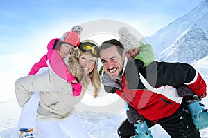 Parents with their children on their backs playing in the snow