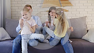 Parents tickling daughters on sofa