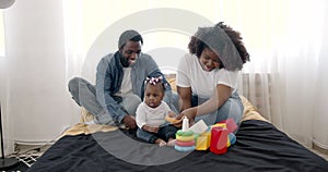 Parents and toddler daughter having fun playing at home