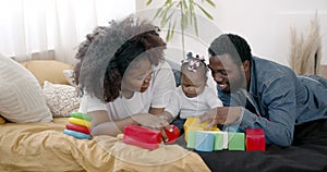 Parents and toddler daughter having fun playing at home