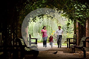 Parents together with daughter run on tunnel