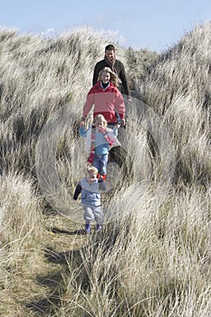 Parents with two children (3-6) walking in long grass