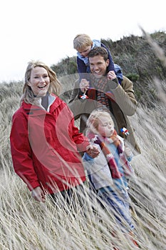 Parents with two children (3-6) walking in long grass