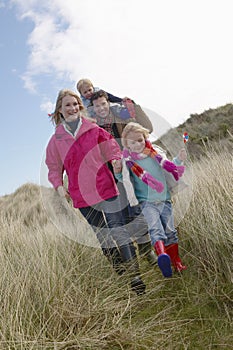 Parents with two children (3-6) walking in long grass