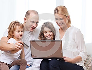 Parents and two girls with laptop and credit card