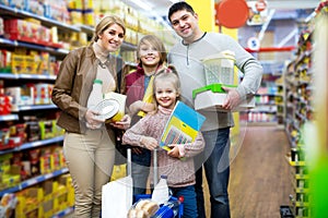 Parents with two kids holding purchases in store