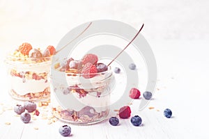 Parfait with granola, berries and yogurt in jars.