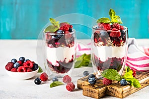 Parfait with granola, jam and fresh berries in the glass jar.