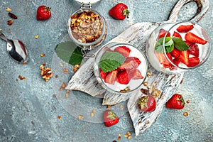 Parfait with yogurt, granola, jam, fresh berries and mint leaves in glass jar. gluten free diet, Healthy breakfast. banner, menu,