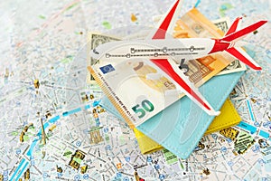 Paris city map composition with euro banknotes, dollars, passports and a toy plane. Travel and vacation concept