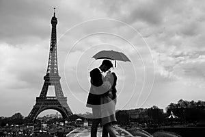 Paris, couple under umbrella near Eiffel tower