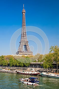 Paris with Eiffel Tower against boats during spring time in France