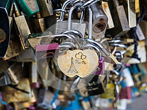 Paris engraved on love lock in closeup of love locks on Paris bridge