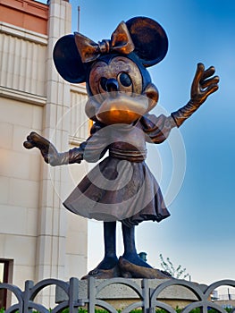 Paris, France - April 2019: Statue of minnie mouse against light blue sky background at disneyland funfair