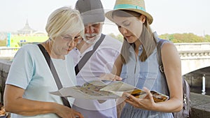 Paris, France - Circa August 2017: Family enjoying vacation. Seniors and their daughter studying map