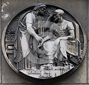 Marc Aurele heals by Galen. Stone relief at the building of the Faculte de Medicine Paris photo