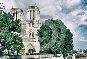 PARIS, FRANCE - JULY 2014: Exterior view of Notre Dame with tourists and Bateau Mouche. This is the most visited landmark in