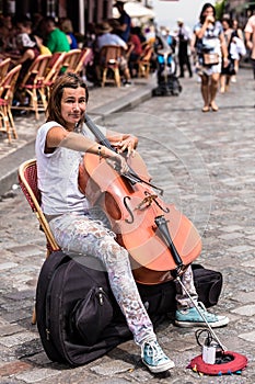 Street musician is playing cello outdoor in the Montmartre district. Paris, France