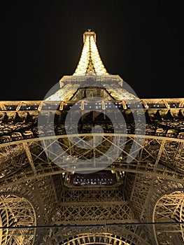 PARIS, FRANCE Ã¢â¬â July 24, 2019: View from below the Eiffel Tower at night. The beams of light, directed from the bottom towards