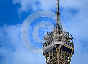 Paris, France, June 2022. Detail of the tip of the Eiffel Tower. A tangle of antennas, recognizable human figures of tourists who