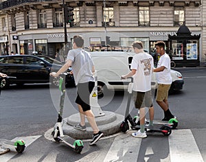 Paris, FRANCE - June 27, 2019: people with Lime electric scooters, rented through a mobile app and dropped off anywhere in the