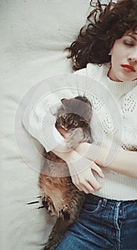 PARIS, FRANCE - MAY 04, 2023: beautiful girl lies with her cat in bed