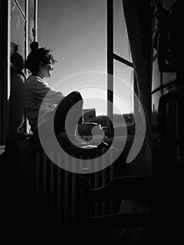 PARIS, FRANCE - MAY 04, 2023: a girl sits on a window on a sunny day