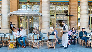 Paris France people drinking coffee on the terrace of a cafe restaurant during the Autumn