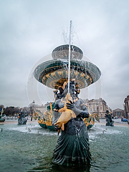 Paris, France, Place de la Concorde fountain detail at winter time.  Nereid holds fish which spout water upwards to the rim of the