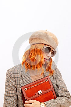 Paris Lady in fashion elegant outfit. Trendy beige beret, sunglasses and stylish plaid blazer. Red velvet clutch. Style in details