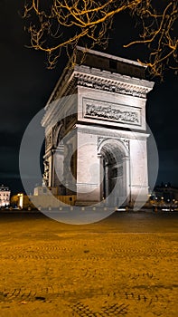 PARIS - March 10, 2023: The Arch of Triumph of the Star The Arc de Triomphe de l'Etoile and traffic lights at night. Paris