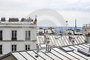 Paris rooftops with chimneys and ventilation pipes overlooking the Eiffel Tower