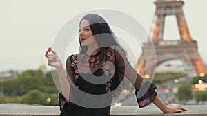 Paris woman smiling eating the french pastry macaron in Paris against Eiffel tower.