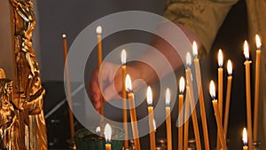 The parishioner put a candle inside an Orthodox church