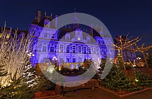 Parisian City Hall decorated with Christmas trees for winter holidays at night. Winter travel and tourist attractions in