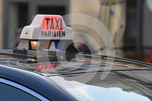 Parisian Taxi sign and car circulating with customer in the Paris streets photo