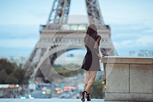 Parisian woman near the Eiffel tower in Paris, France.