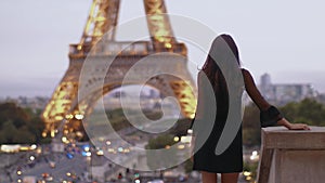 Parisian woman near the Eiffel tower in Paris, France.