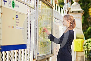 Parisian woman near the subway plan, looking for the direction