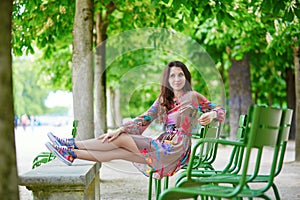 Parisian woman relaxing in the Tuileries garden on a sunny summer day