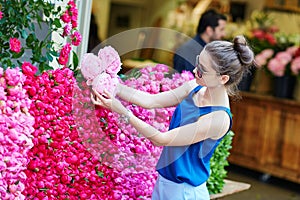 Parisian woman selecting peonies in flower shop