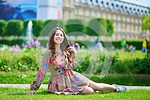 Parisian woman in the Tuileries garden sitting on the grass