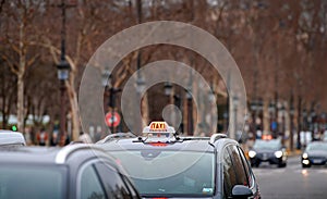 Parisien Taxi on Champs Elysee boulevard in the evening