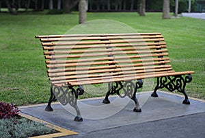 Park bench seat and green lawn behind